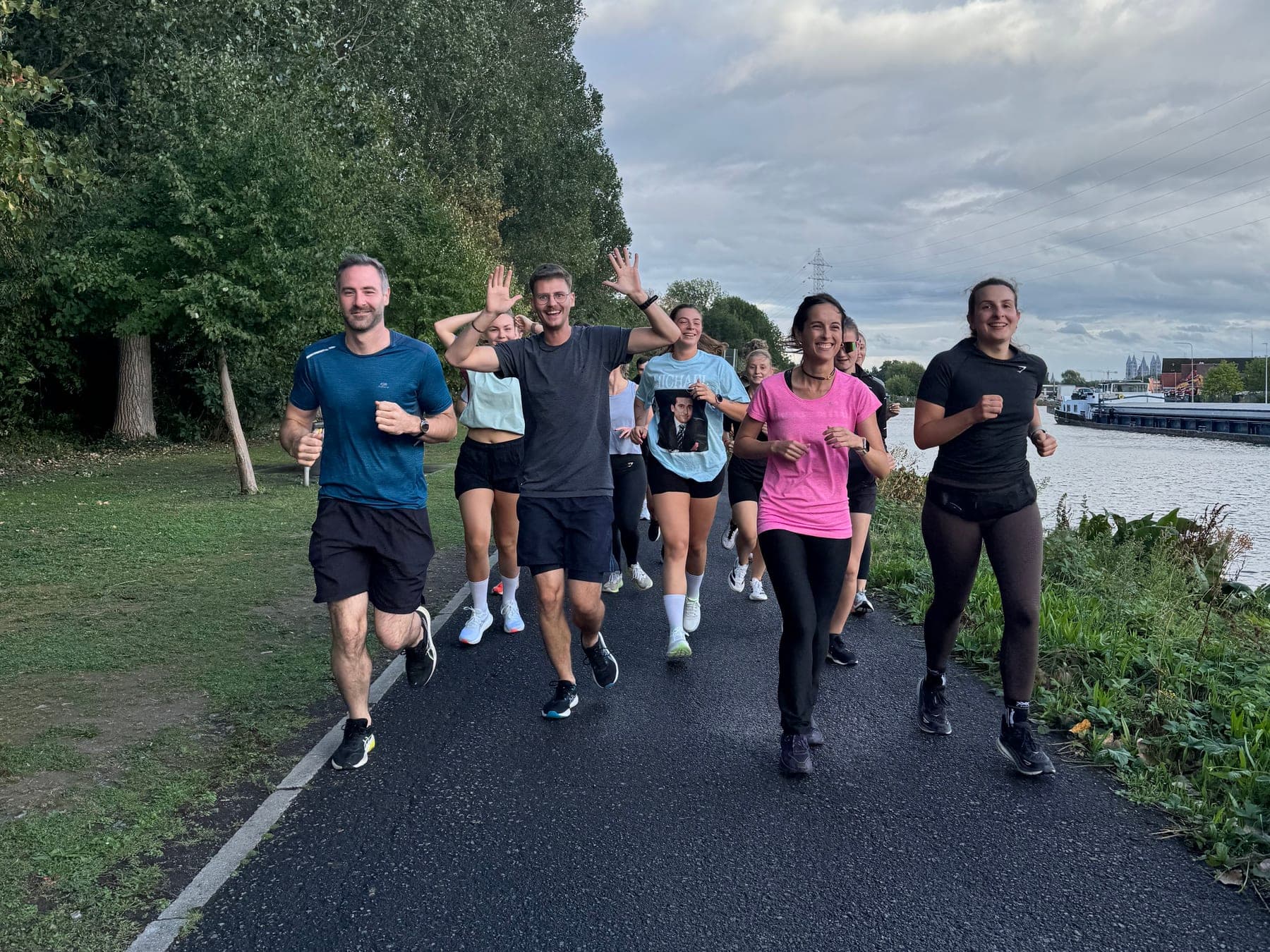 Le clan en pleine sortie le long de l'eau, des coureurs saluent en passant
