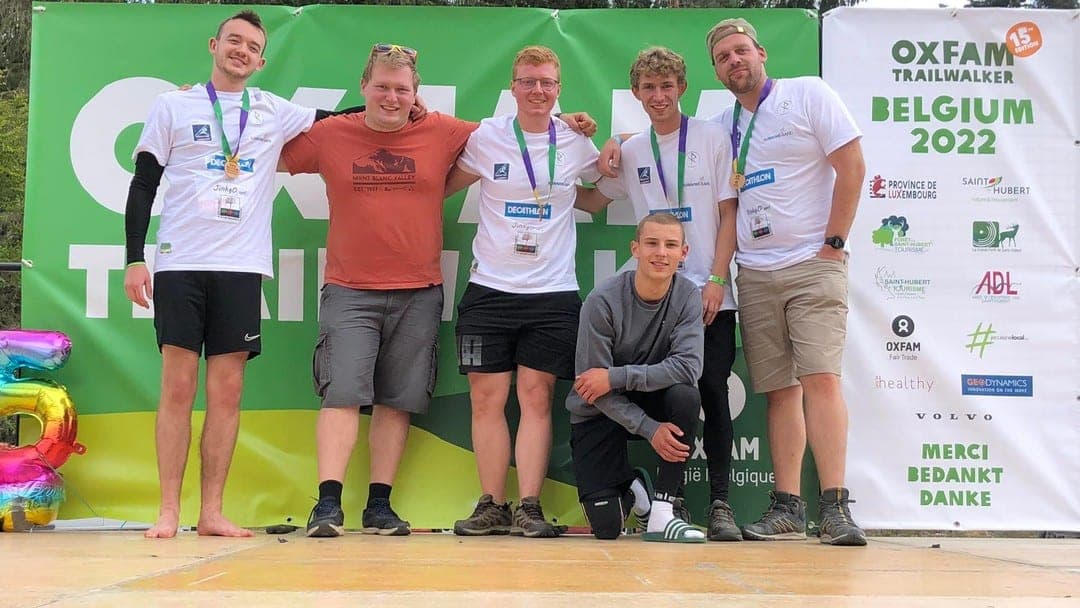 Sur le podium de l'Oxfam Trailwalker Belgium 2022, les quatre coureurs médaillés et les deux copains du ravito