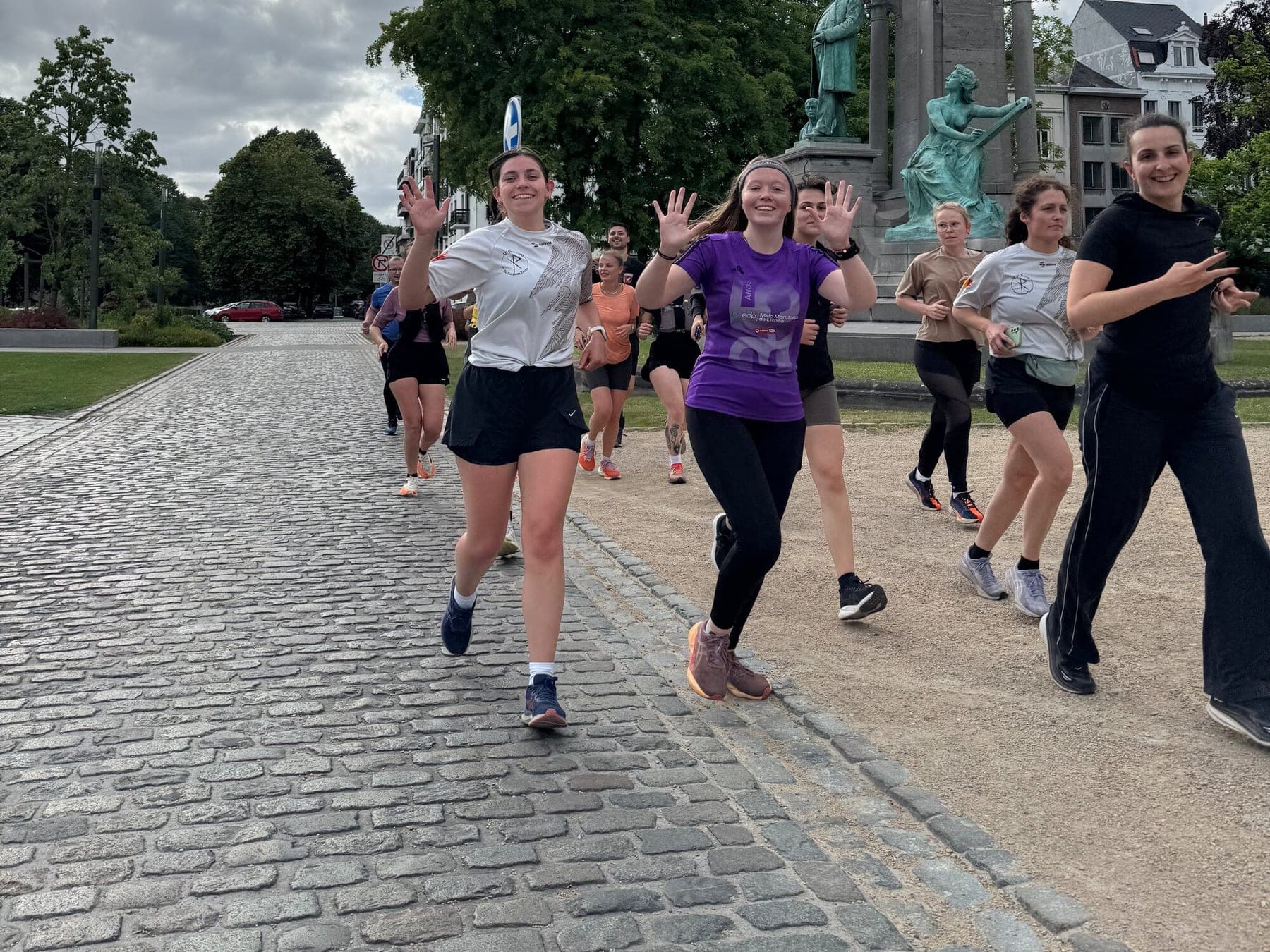 Des coureuses du clan saluent l'objectif en courant sur les pavés