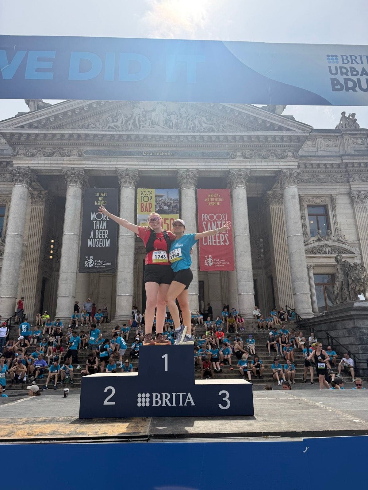 Deux V'Hikings posent sur le podium du Brita Urban Trail, devant la Bourse de Bruxelles